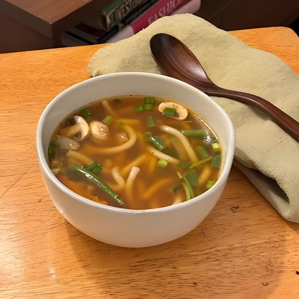 A bowl of Wat Dong Moon Lek Noodle's Thai noodle soup with mushrooms and green onions.
