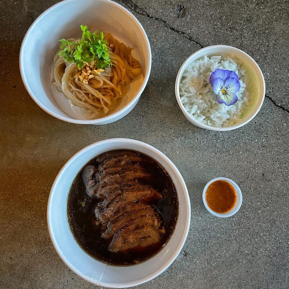 Wat Dong Moon Lek Noodle's Thai dishes: noodles, rice with a purple flower, and a rich meat stew.