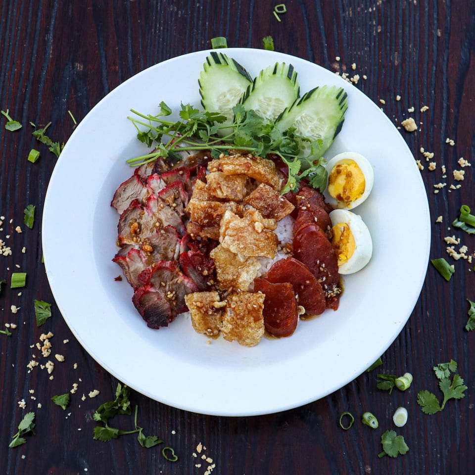 Wat Dong Moon Lek Noodle's Thai dish with sliced pork, crispy pork belly, sausage, and eggs.